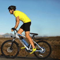Man som kör VARUN M24-1 elmountainbike i färgen vit med hjälm på en väg