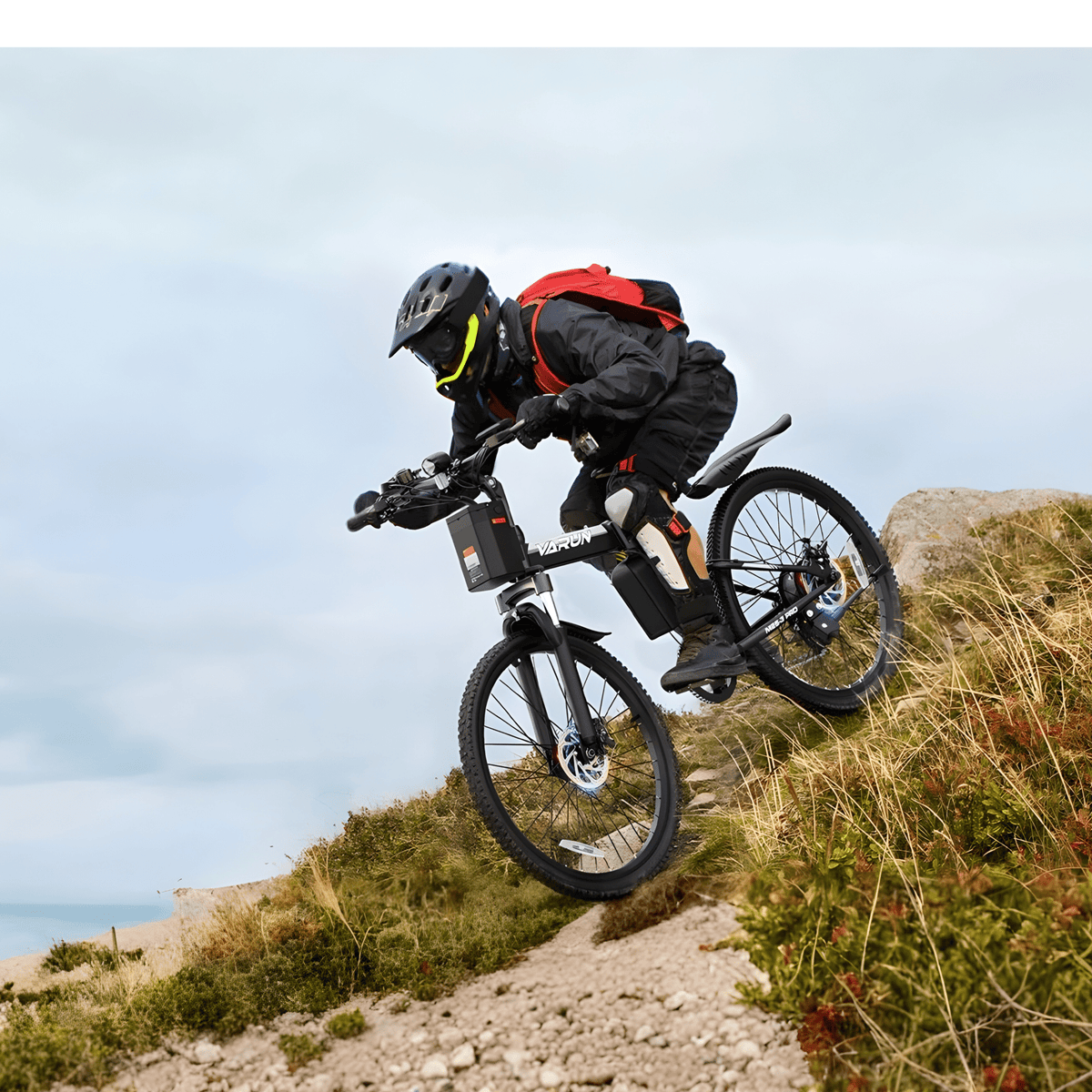 Förare gör ett hopp med VARUN M26-3 Pro elmountainbike med hjälm
