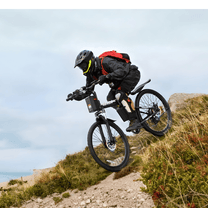 Förare gör ett hopp med VARUN M26-3 Pro elmountainbike med hjälm