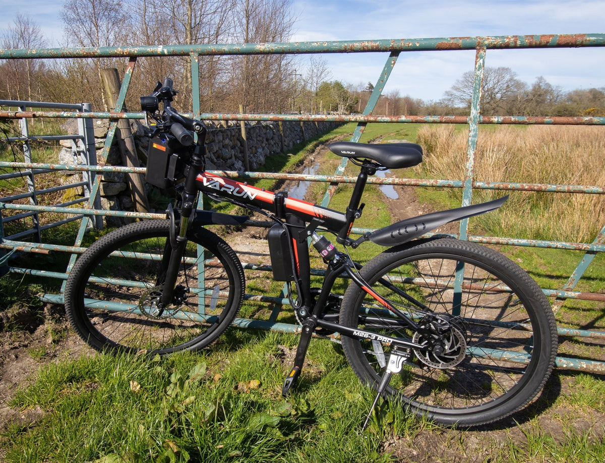 VARUN M26-3 Pro elmountainbike sedd från sidan i färgen svart parkerad på en gräsplan