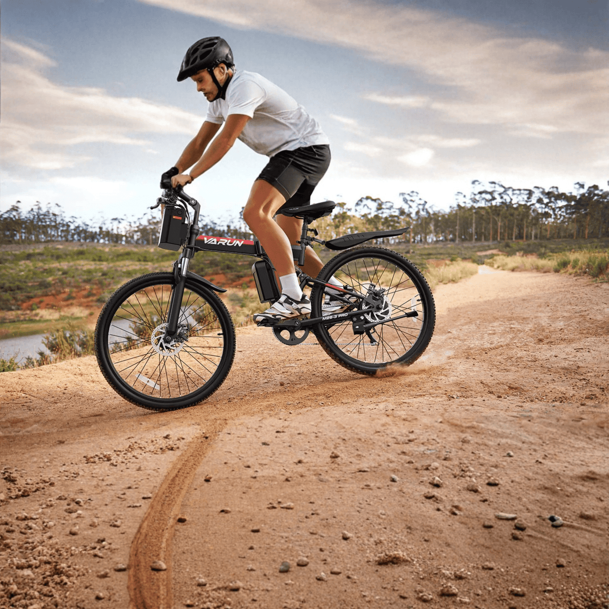 Man som kör VARUN M26-3 Pro elmountainbike i färgen svart med hjälm på en stig