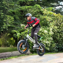 Man som kör VARUN S20-1 hopfällbar fatbike-elcykel i färgen beige med hjälm i skogen