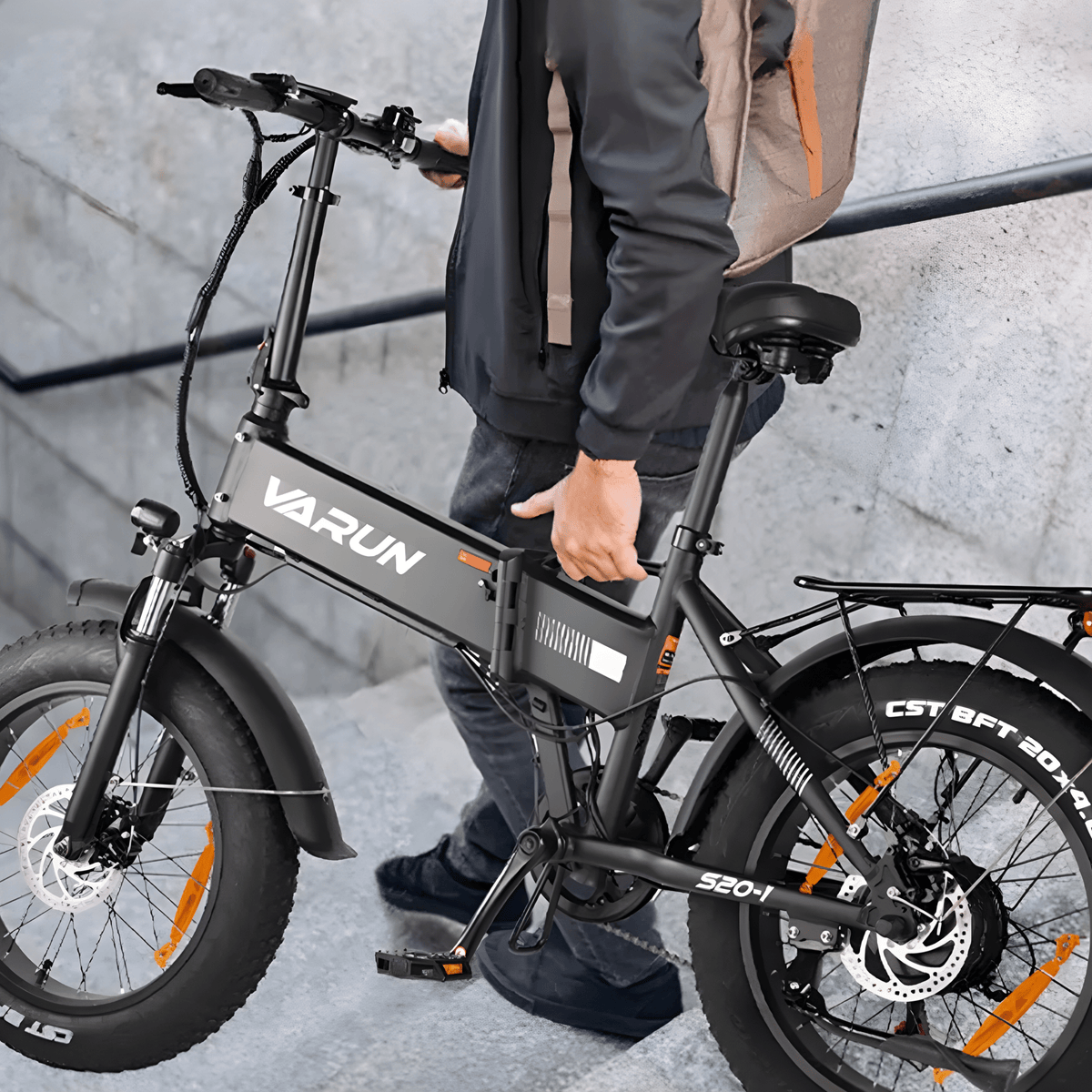 Person står med VARUN S20-1 hopfällbar fatbike-elcykel i färgen svart
