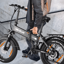 Person står med VARUN S20-1 hopfällbar fatbike-elcykel i färgen svart
