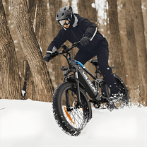 Man som kör VARUN S26-1 fatbike-elcykel i färgen svart med hjälm i snö