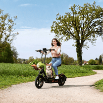 Kvinna som kör Wheely H14 elsparkcykel i en park